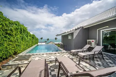 a patio with chairs and a swimming pool at mona seaview pool villa beach front AoYon Beach in Panwa Beach