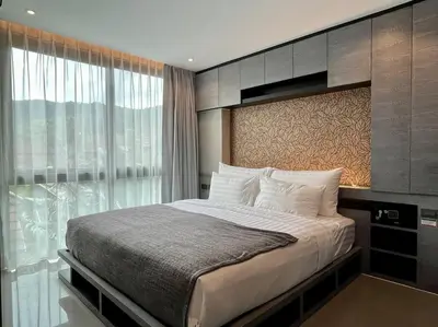 a bedroom with a bed and a large window at Kamala Beach D68 Exclusive Junior Suite in Kamala Beach