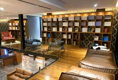 a library with bookshelves and couches in a room at Kamala Beach D68 Exclusive Junior Suite in Kamala Beach