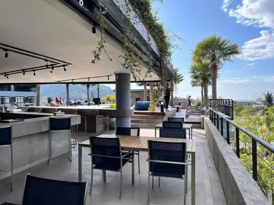 a patio with chairs and a table and a bar at Kamala Beach D68 Exclusive Junior Suite in Kamala Beach