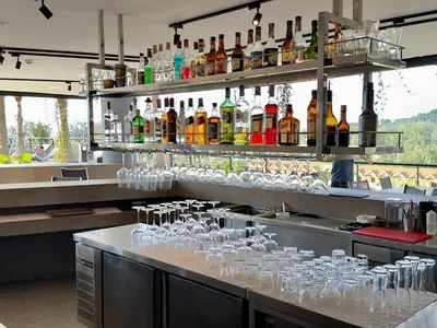 a bar with many glasses on a counter with drinks at Kamala Beach D68 Exclusive Junior Suite in Kamala Beach