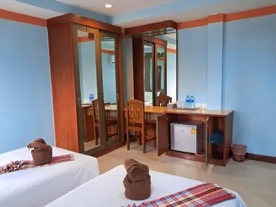 a room with two beds and a table with a desk at Baan Thara Guesthouse in Ao Nang Beach