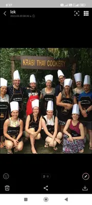 a group of people wearing chefs hats posing for a picture at Baan Thara Guesthouse in Ao Nang Beach