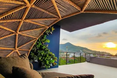 a room with a balcony with a view of a mountain at Kamala Beach P15 Pool view Suite in Kamala Beach