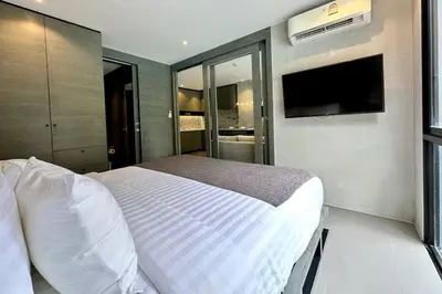 a bedroom with a bed and a flat screen tv at Kamala Beach P15 Pool view Suite in Kamala Beach