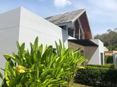 a white house with green plants in front of it at Villa B23 Phuket in Nai Yang Beach