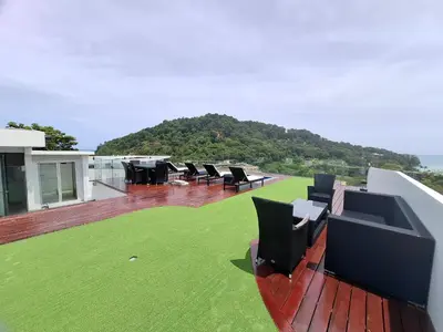 a house with a deck with chairs on it at Twin Sands Resort Penthouse in Patong Beach