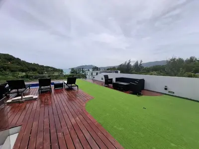 a deck with chairs and a lawn on a house at Twin Sands Resort Penthouse in Patong Beach