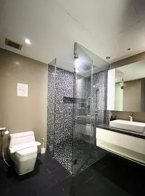 a bathroom with a shower and a toilet and a sink at Twin Sands Resort Penthouse in Patong Beach