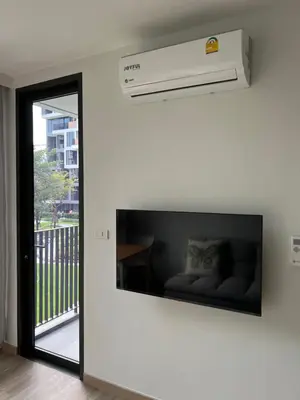 a living room with a large flat screen tv on the wall at Skypark view golf Laguna Phuket in Bang Tao Beach