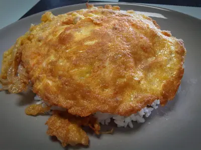 a piece of food on a plate with rice at Lay Back Villa C1 with kitchen & High Speed Internet in Krabi town