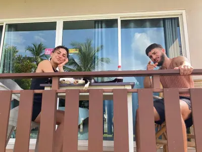 a man and a woman on a balcony with a dog at Lay Back Villa C1 with kitchen & High Speed Internet in Krabi town