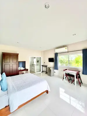 a bedroom with a large bed and a table at Lay Back Villa C1 with kitchen & High Speed Internet in Krabi town