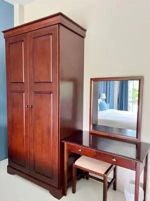 a dresser with a mirror next to a wooden cabinet at Lay Back Villa C1 with kitchen & High Speed Internet in Krabi town