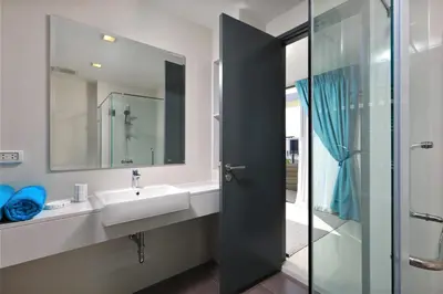 a bathroom with a sink and a glass shower door at Laguna Park 2 in Phuket Town