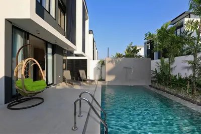 a house with a swimming pool next to a building at Laguna Park 2 in Phuket Town
