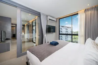 a bedroom with a large bed and a large window at Tropics Kamala 2BR Apartment CTG B605-6 in Kamala Beach
