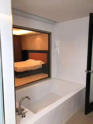 a bathroom with a mirror over a sink and a bed at Kamala Regent : Beautiful Modern Apartment close to Kamala beach in Kamala Beach