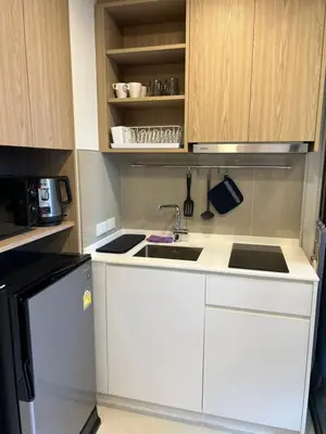 a kitchen with white cabinets and a sink at SKYPARK Building A Laguna Phuket in Bang Tao Beach