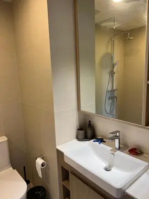 a bathroom with a sink and a mirror and a toilet at SKYPARK Building A Laguna Phuket in Bang Tao Beach