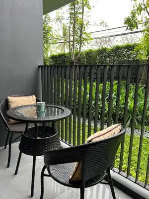a patio with two chairs and a table and a table and chairs at SKYPARK Building A Laguna Phuket in Bang Tao Beach