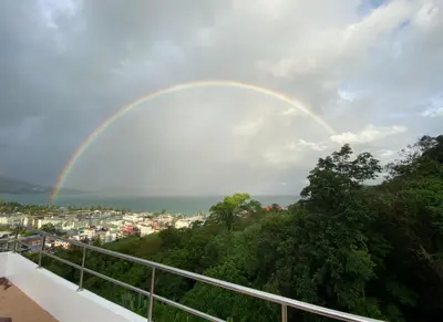 a rainbow in the sky over a city at Andaman Hill Pool Seaview in Patong Beach