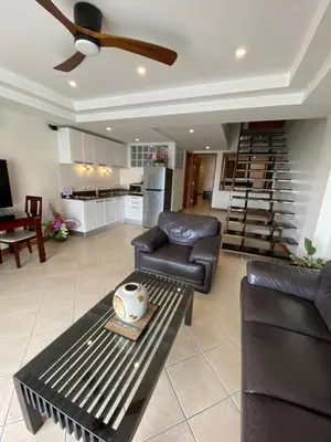 a living room with a couch and chairs and a staircase at Andaman Hill Pool Seaview in Patong Beach
