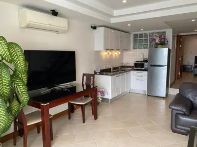 a living room with a table and a kitchen at Andaman Hill Pool Seaview in Patong Beach