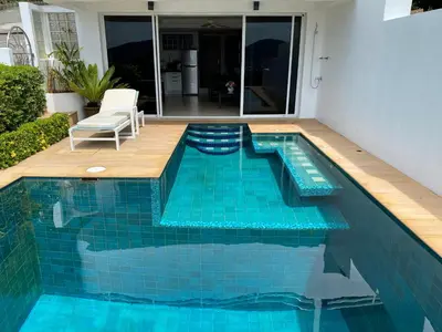 a swimming pool with blue tiles in a house at Andaman Hill Pool Seaview in Patong Beach