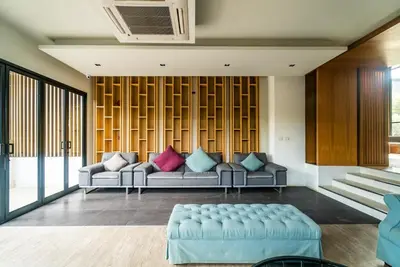 a living room with a couch with colorful pillows at Private apartment at Aristo Resort by Lofty in Surin Beach