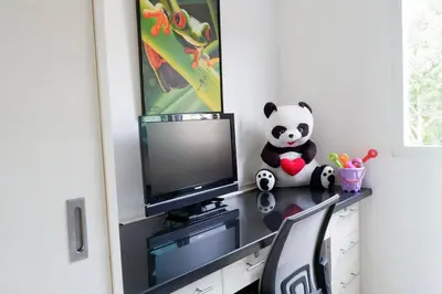 a room with a tv and a panda bear sitting on a desk at Kata Ocean View Luxury condo & Seaview K12 in Kata Beach