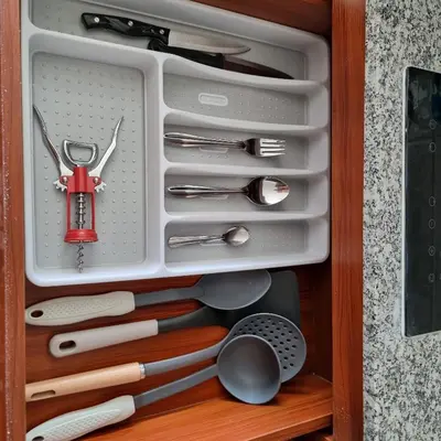 a drawer full of kitchen utensils in a cabinet at 777 Beach Condo Phuket in Mai Khao Beach