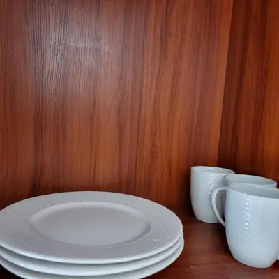 a table with two white plates and two cups at 777 Beach Condo Phuket in Mai Khao Beach