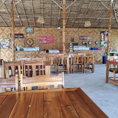 a dining room with wooden tables and benches at 777 Beach Condo Phuket in Mai Khao Beach