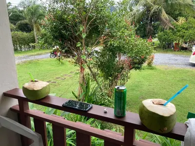 two melons sitting on a wooden bench with a remote control at Lay Back Villa C3 with Kitchen & High Speed Internet in Ban Laem Som