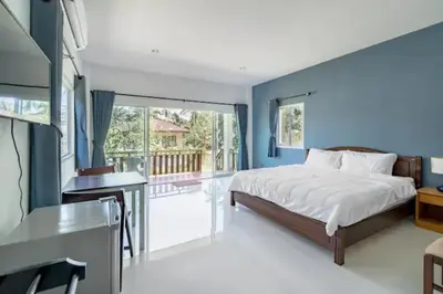 a bedroom with blue walls and a bed and a desk at Lay Back Villa C3 with Kitchen & High Speed Internet in Ban Laem Som