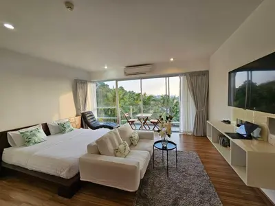 a bedroom with a white bed and a large window at Sunset Residence Karon Beach in Karon Beach