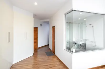 a hallway with white walls and a glass wall at Sunset Residence Karon Beach in Karon Beach