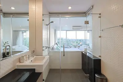 a bathroom with a sink and a glass shower at Sunset Residence Karon Beach in Karon Beach