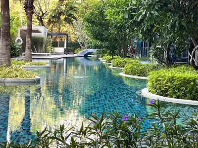 a pool in the middle of a garden with trees at Aristo O59 Junior Suite Surin Beach in Phuket Town