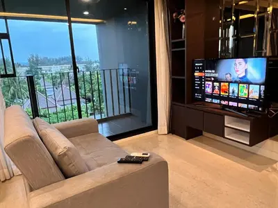 a living room with a couch and a flat screen tv at Aristo O59 Junior Suite Surin Beach in Phuket Town