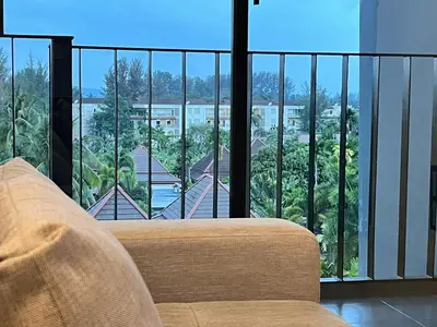 a living room with a couch and a large window at Aristo O59 Junior Suite Surin Beach in Phuket Town