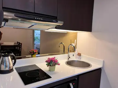 a kitchen with a sink and a counter top at Aristo O59 Junior Suite Surin Beach in Phuket Town