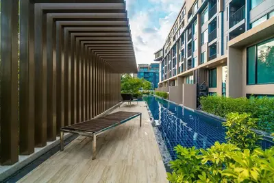 a bench sitting on the side of a building at Aristo O59 Junior Suite Surin Beach in Phuket Town