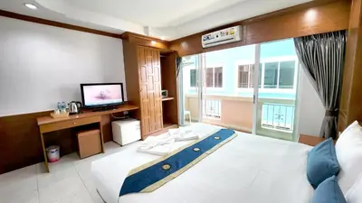 a bedroom with a large bed and a television in it at Chalita House in Patong Beach
