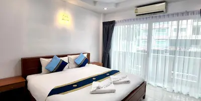 a bedroom with a large bed with a large window at Chalita House in Patong Beach