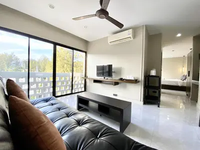 a living room with a couch and a tv at Mamatel boutique in Kamala Beach
