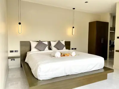 a bedroom with a large white bed with three pillows at Mamatel boutique in Kamala Beach