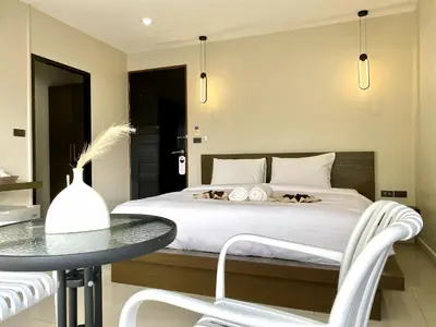 a bedroom with a bed and a table and chairs at Mamatel boutique in Kamala Beach