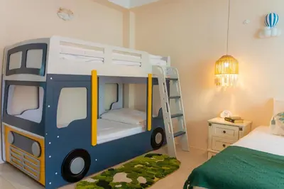 a toy bus bedroom with a bunk bed and a ladder at Patong Beach Side Hotel in Patong Beach